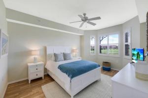 1 dormitorio blanco con 1 cama y ventilador de techo en Beautiful 2 bedroom condo w/ Golf Membership Included en Naples