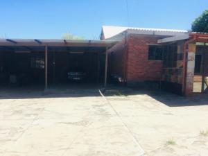 a brick garage with a car parked in it at Tanzanite Guesthouse in Dannhauser