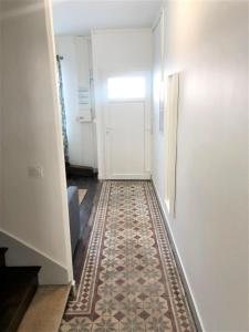 um corredor com piso em azulejo em frente a uma porta em Maison de ville avec cour Place Luton em Reims
