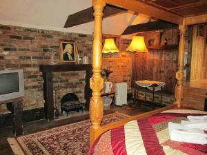 a bedroom with a bed with a fireplace and a television at Red Lion Coaching Inn in Epworth