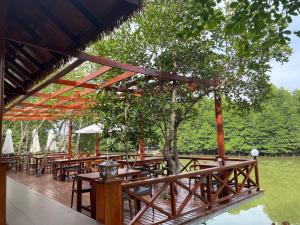 a group of tables on a deck with a tree at O Mary River Resort in Sihanoukville