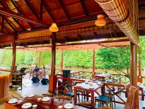 a restaurant with tables and chairs and people in the background at O Mary River Resort in Sihanoukville