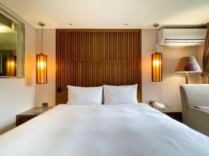Voodi või voodid majutusasutuse Guide Hotel Taipei Bade toas