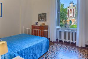- une chambre avec un lit bleu et une fenêtre dans l'établissement Leone I and Leone II Apartments, à Levanto