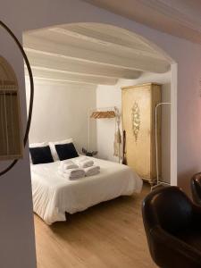 1 dormitorio con 1 cama blanca y 1 silla en Apto. centro histórico Huesca, en Huesca