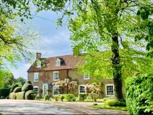 a large brick house with a driveway at The Coach House in Lincolnshire