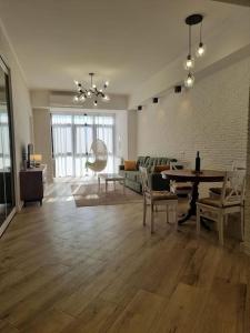 uma grande sala de estar com mesa e cadeiras em Morkinali Apartment em Tbilisi