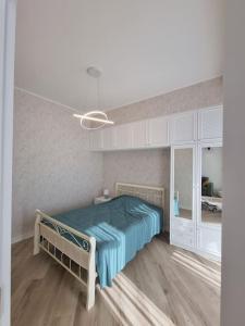 a bedroom with a bed with a blue comforter at Morkinali Apartment in Tbilisi City