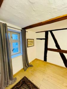 Cette chambre dispose d'une fenêtre et de parquet. dans l'établissement Eine Etage im historischen Gästehaus bei Magdeburg, à Barleben