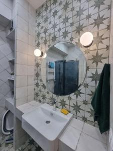 uma casa de banho com um lavatório e um espelho em Morkinali Apartment em Tbilisi