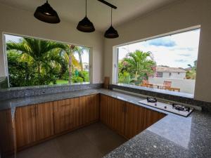 a kitchen with two large windows and a large sink at ELOMY VILLA in Albion