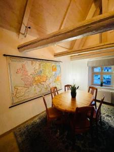 a room with a table and chairs and a map on the wall at Eine Etage im historischen Gästehaus bei Magdeburg in Barleben