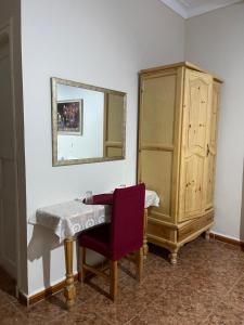 een kamer met een tafel, een spiegel en een kast bij Hotel plage d'or in Jijel