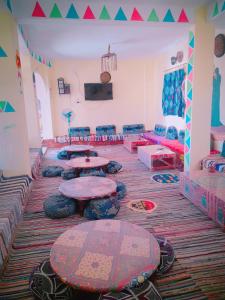 Lawanda Nubian House في أسوان: غرفة بها طاولات وأرائك في غرفة