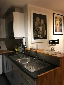 a kitchen counter with a sink and a painting on the wall at Caravaggio Boutique Suites in Antwerp