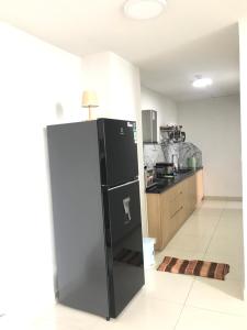 eine Küche mit einem schwarzen Kühlschrank im Zimmer in der Unterkunft Căn hộ Vip siêu rộng, siêu sang, giá tốt chung cư Celadon, ngay Aeon Tân Phú in Ho-Chi-Minh-Stadt
