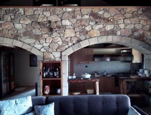 a living room with a couch and a stone wall at Spacious rustic country house with sea view in Maronia