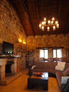 a living room with a couch and a fireplace at Spacious rustic country house with sea view in Maronia