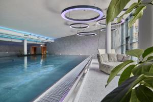 a swimming pool with a chair and a couch in a building at Riders In in Sölden