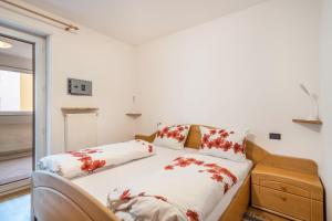 a bedroom with a bed with red flowers on it at Appartement Laurin in Merano