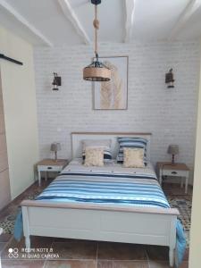 - une chambre dotée d'un lit avec des draps bleus et blancs dans l'établissement O’Pontpoint d’Autrefois, 