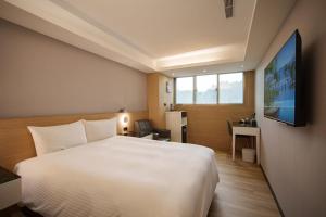 Pokój hotelowy z dużym łóżkiem i telewizorem w obiekcie HUB HOTEL Tucheng w mieście Tucheng