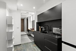 a kitchen with black cabinets and a black counter top at Renovated apt on Frishman beach with Bomb Shelter M8 in Tel Aviv