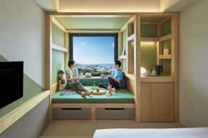 那霸的住宿－OMO5 Okinawa Naha by Hoshino Resorts，两人坐在窗户的房间