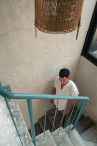 a man sitting on the stairs next to a blue table at Dechiu in Hoi An