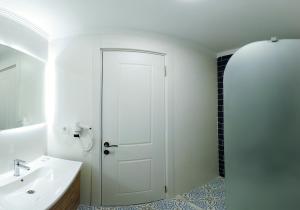a bathroom with a white door and a sink at HOUDİNİ HOTEL in Urla