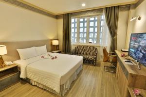 ein Hotelzimmer mit einem Bett und einem Sofa in der Unterkunft Lotus Saigon Hotel in Ho-Chi-Minh-Stadt