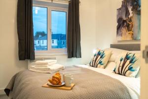 um quarto com uma cama com uma bandeja de comida em The Mews, Amazing Newport 2 BR, Excellent location, Parking, Perfect for Contractors em Newport