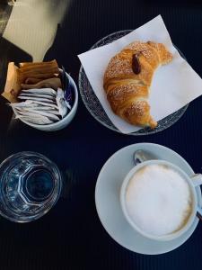 un tavolo con un piatto di pane e una tazza di caffè di Beb Alla Marina Tortora a Tortora