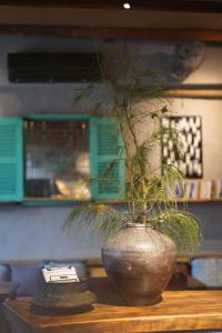 a vase with a plant in it on a table at Dechiu in Hoi An