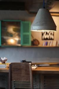 a wooden table with a chair and a pendant light at Dechiu in Hoi An