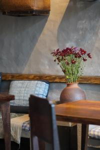 a table with a vase with flowers on it at Dechiu in Hoi An