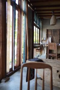 a living room with windows and a table and chairs at Dechiu in Hoi An