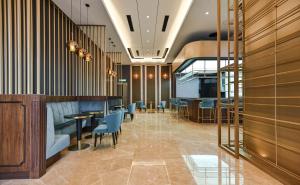 un restaurante con sillas y mesas azules en una habitación en AXQUISITE SUITES at KLCC, en Kuala Lumpur