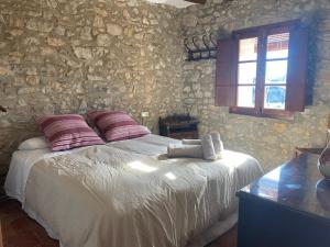 a bedroom with a bed and a stone wall at Masía La Perera in Morella +34 photos