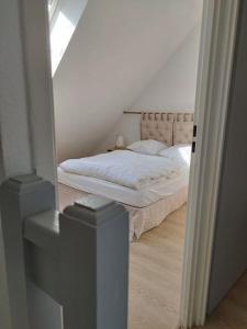 Un dormitorio con una cama con sábanas blancas. en APPT 4P - Manoirs 1 à la Mer Chez Claudette & Marc, en Courseulles-sur-Mer