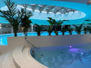a swimming pool in a building with plants at Hotel Dana Business & Conference in Szczecin