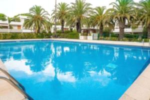 duży niebieski basen z palmami w tle w obiekcie Location Grande Motte vacances w mieście La Grande-Motte