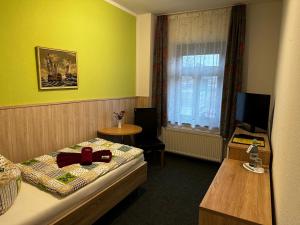 a room with a bed and a table and a window at Pension Anni in Sanitz