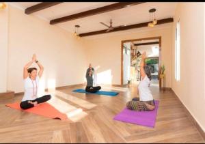 um grupo de pessoas a fazer yoga numa sala em The Rudraksh, A Himalayan Retreat em Kandikhal