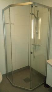 eine Dusche mit Glastür im Bad in der Unterkunft Telemark Motel and Apartment in Hauggrend