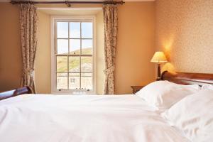 a bedroom with a large bed and a window at The Wellington Hotel in Boscastle