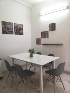 a dining room with a white table and chairs at Hua Tang Homestay in Ipoh