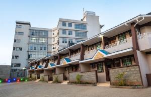 a large building with a parking lot in front of it at Gardens Executive Suites in Kikuyu