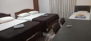 帕納吉的住宿－ANGELO'S - 2 HOLIDAY VILLAS IN PANAJI, NORTH GOA，酒店客房设有两张床和一张桌子。