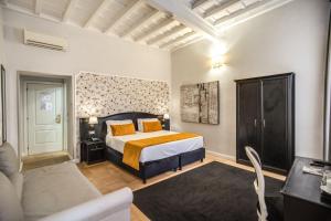 um quarto com uma cama king-size e um sofá em Relais Fontana Di Trevi Hotel em Roma
